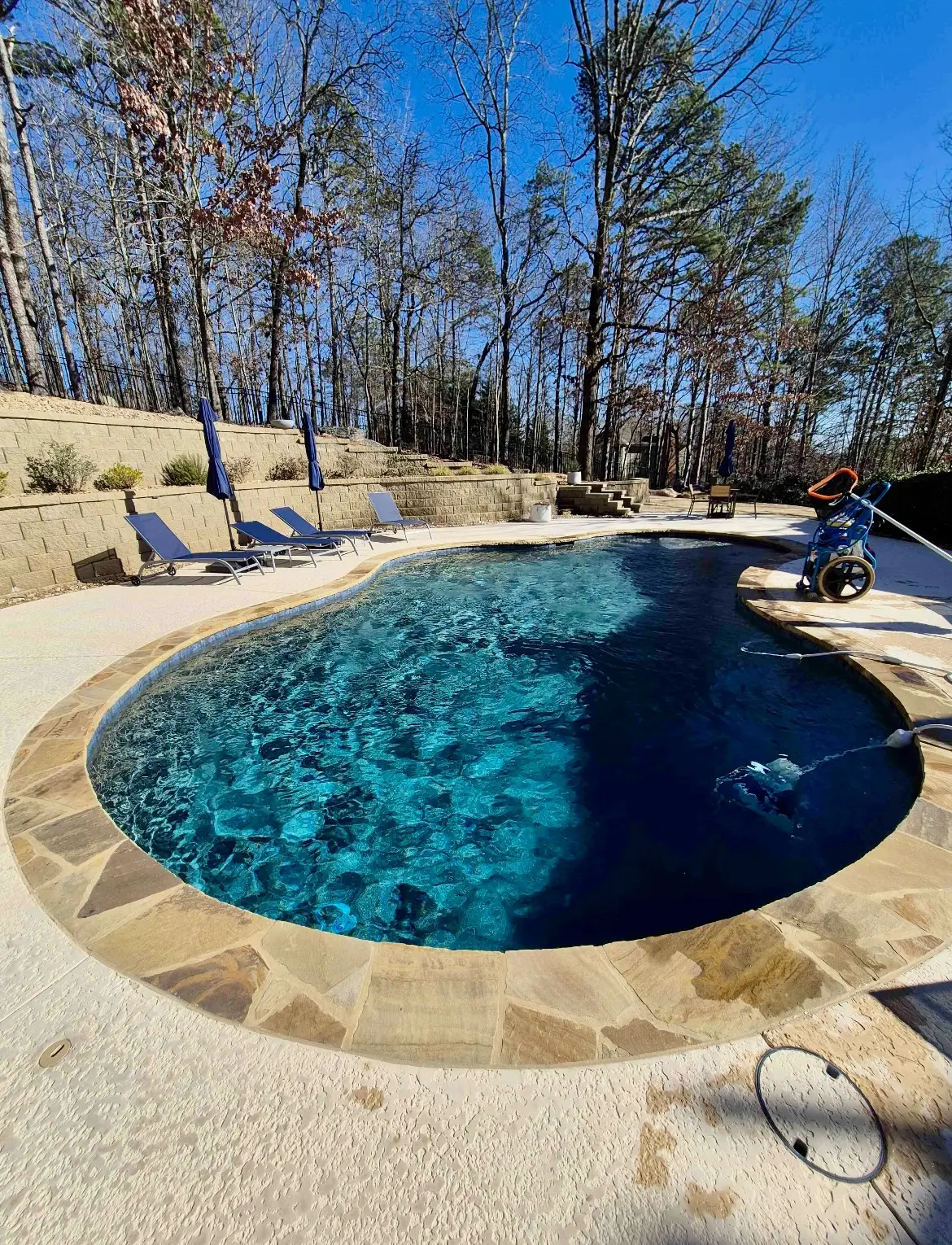 Routine cleaning underway in a clear freeform pool